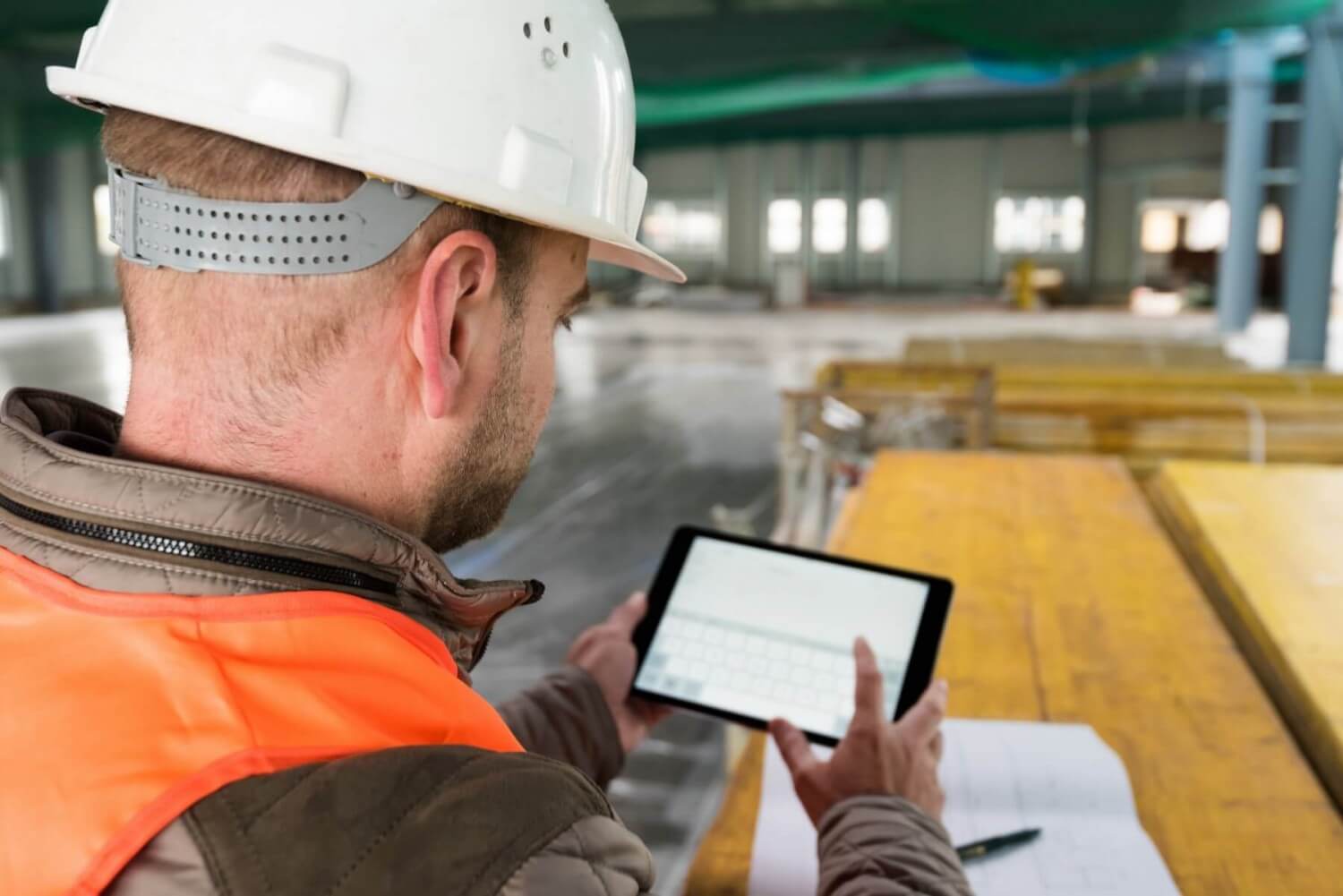 Construction Worker In The Building Site With His Digital Tablet - Making A Claim - McLarens
